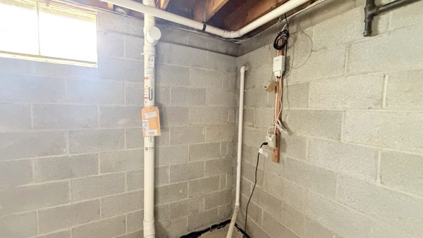 Basement with visible radon mitigation piping and components