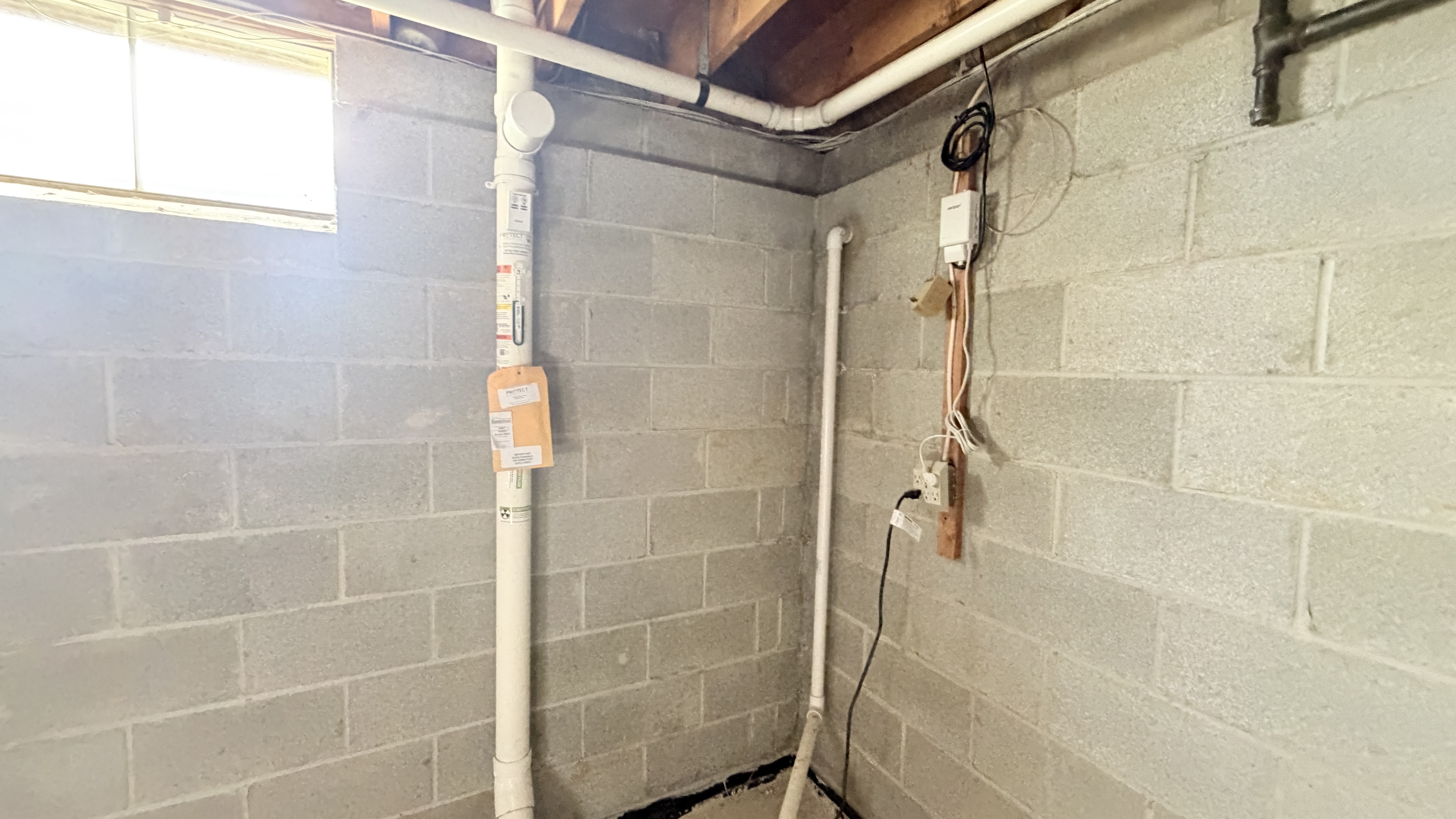 Basement with visible radon mitigation piping and components