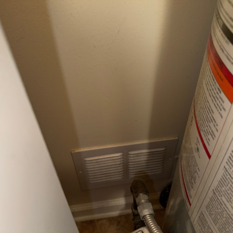 Low combustion air vent near gas water heater in utility room