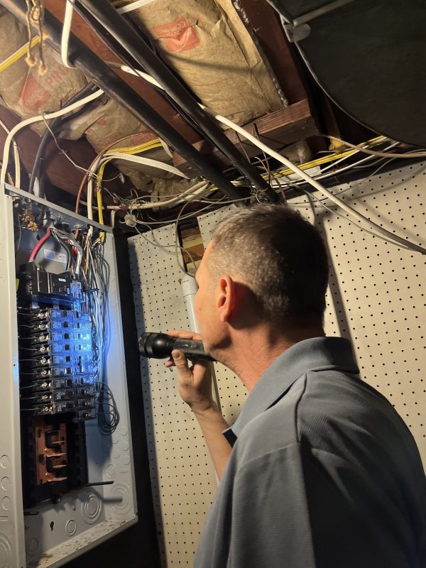 Home inspector evaluating electrical panel during a New Jersey home inspection