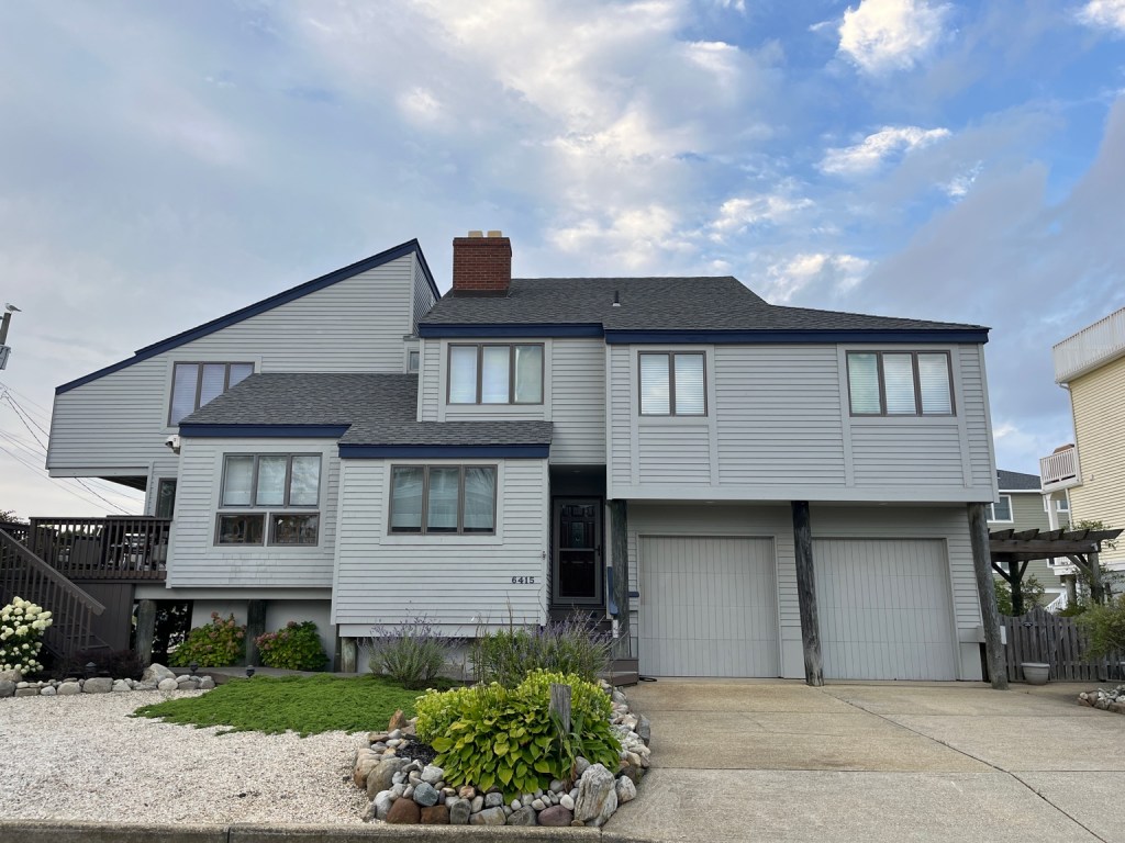 Gray elevated coastal shore house with garage below inspected by Dynamic Inspections LLC in New Jersey
