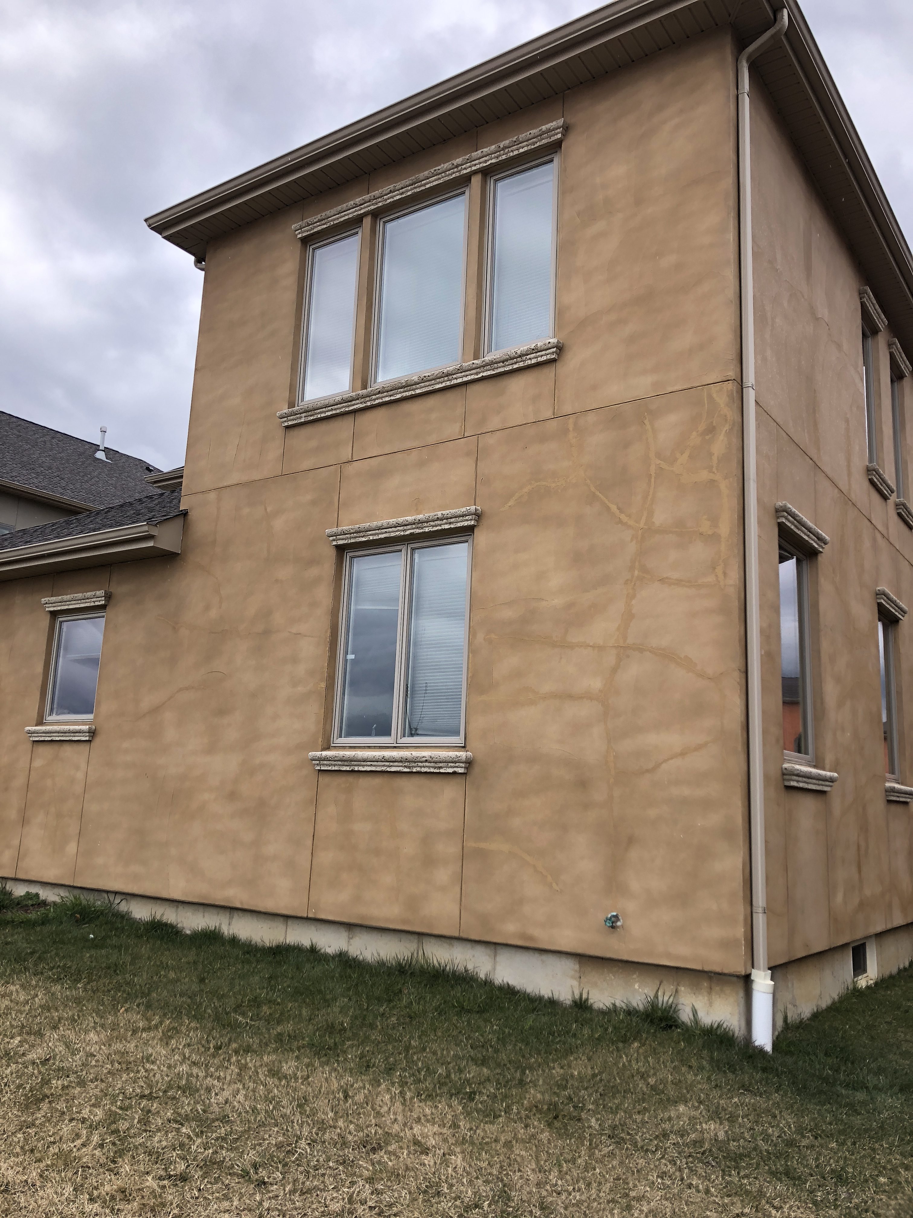 Cracking stucco exterior wall showing deferred maintenance and moisture intrusion damage