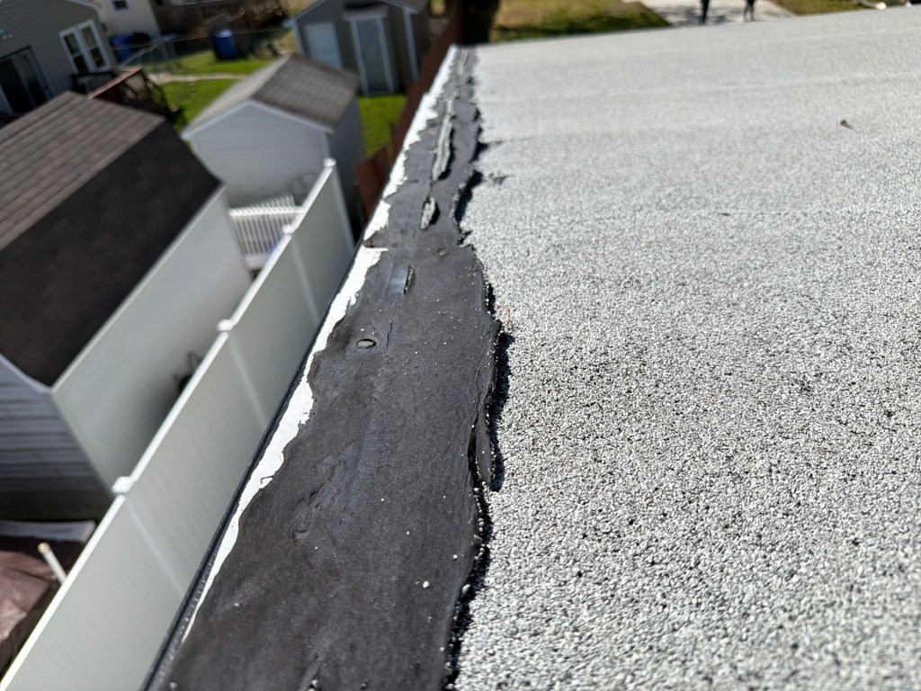 deteriorated flat roof edge flashing with cracking and separation
