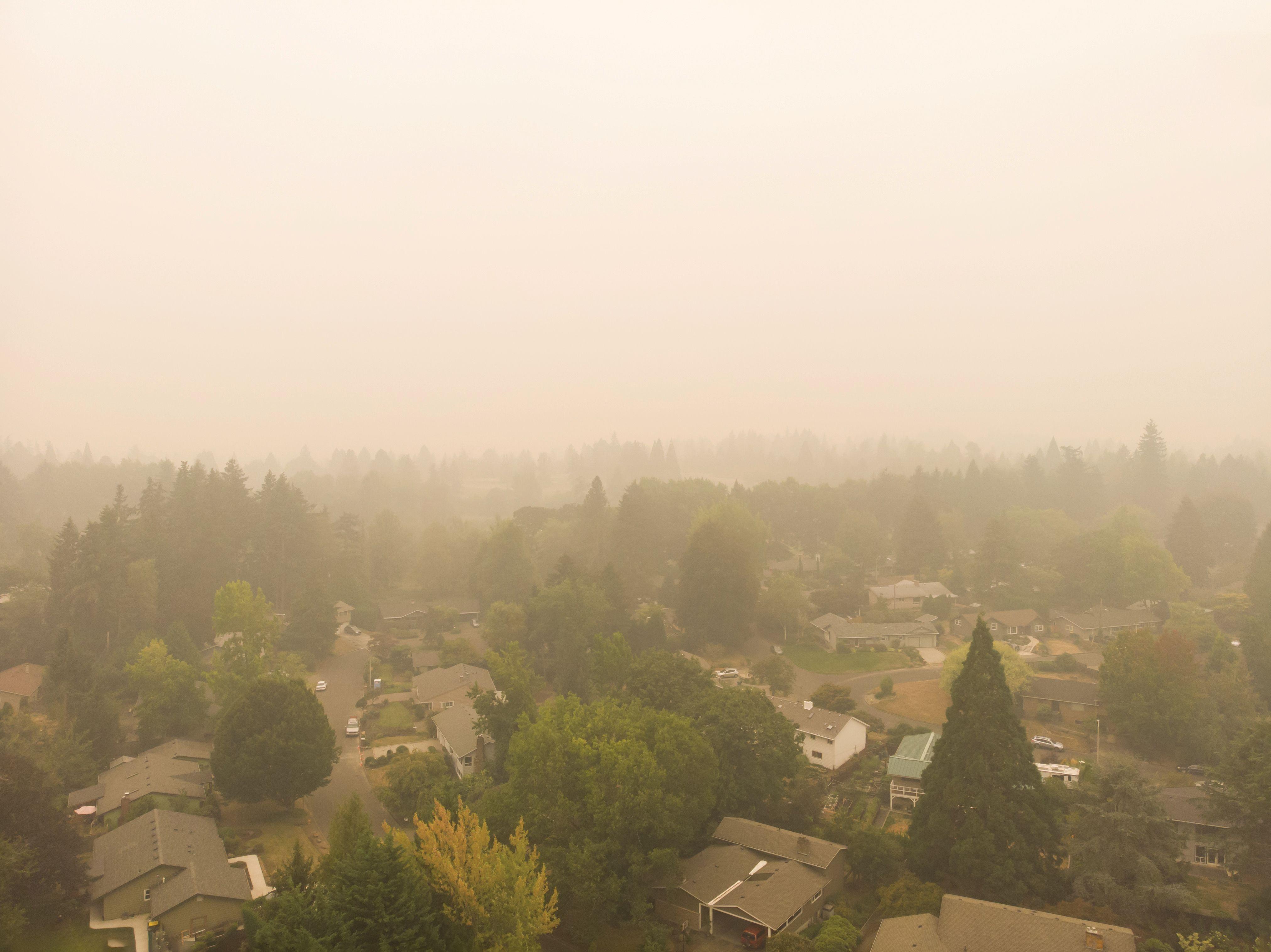 Wildfire smoke creating hazy conditions over a residential neighborhood.